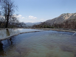 三斗小屋温泉 煙草屋の青空のもと山々を望む広大な野天風呂の写真