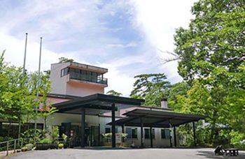 かんぽの宿塩原の木々に囲まれた正面入口を撮影した外観の写真