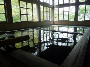 三斗小屋温泉 大黒屋の格子越しに外の光が映し出されている大浴場の写真