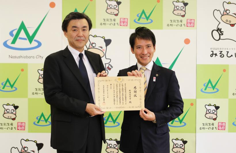 感謝状授与式にて、渡辺市長と小山大田原税務署長が二人で感謝状を掲げつつ記念撮影に応じている様子の写真