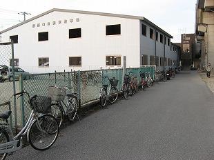 道のフェンス横に放置されている何台もの自転車の写真