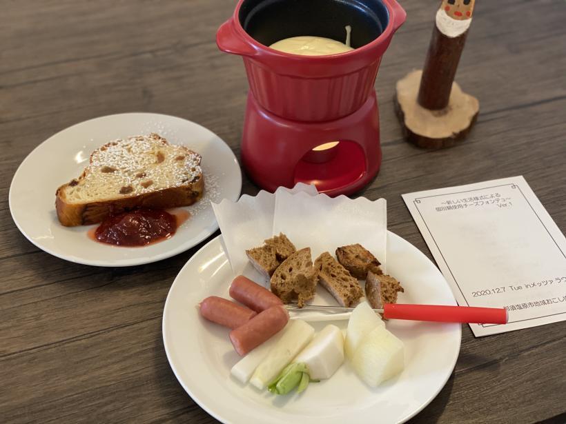 赤い個別鍋にチーズソースが入っていてパンや野菜やソーセージが小皿に用意されている写真