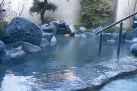 かんぽの宿にある青っぽい色の岩でできた露天風呂の写真