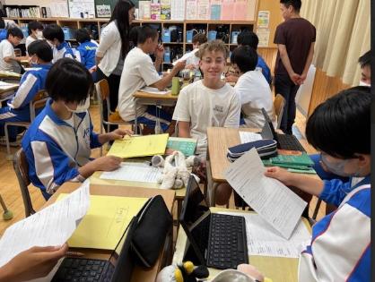 中学校の授業の様子。中学生4名がグループになっていて、アウホフ校の生徒と会話をしている。