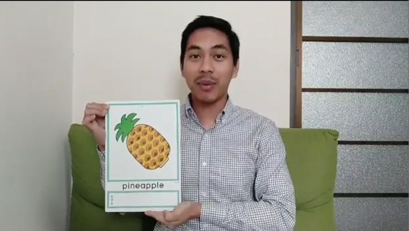 動画の中で、ジョセフさんがパイナップルのイラストを見せながら、自分が好きな果物がパイナップルである、と英語で発音しているシーンを切り取った写真