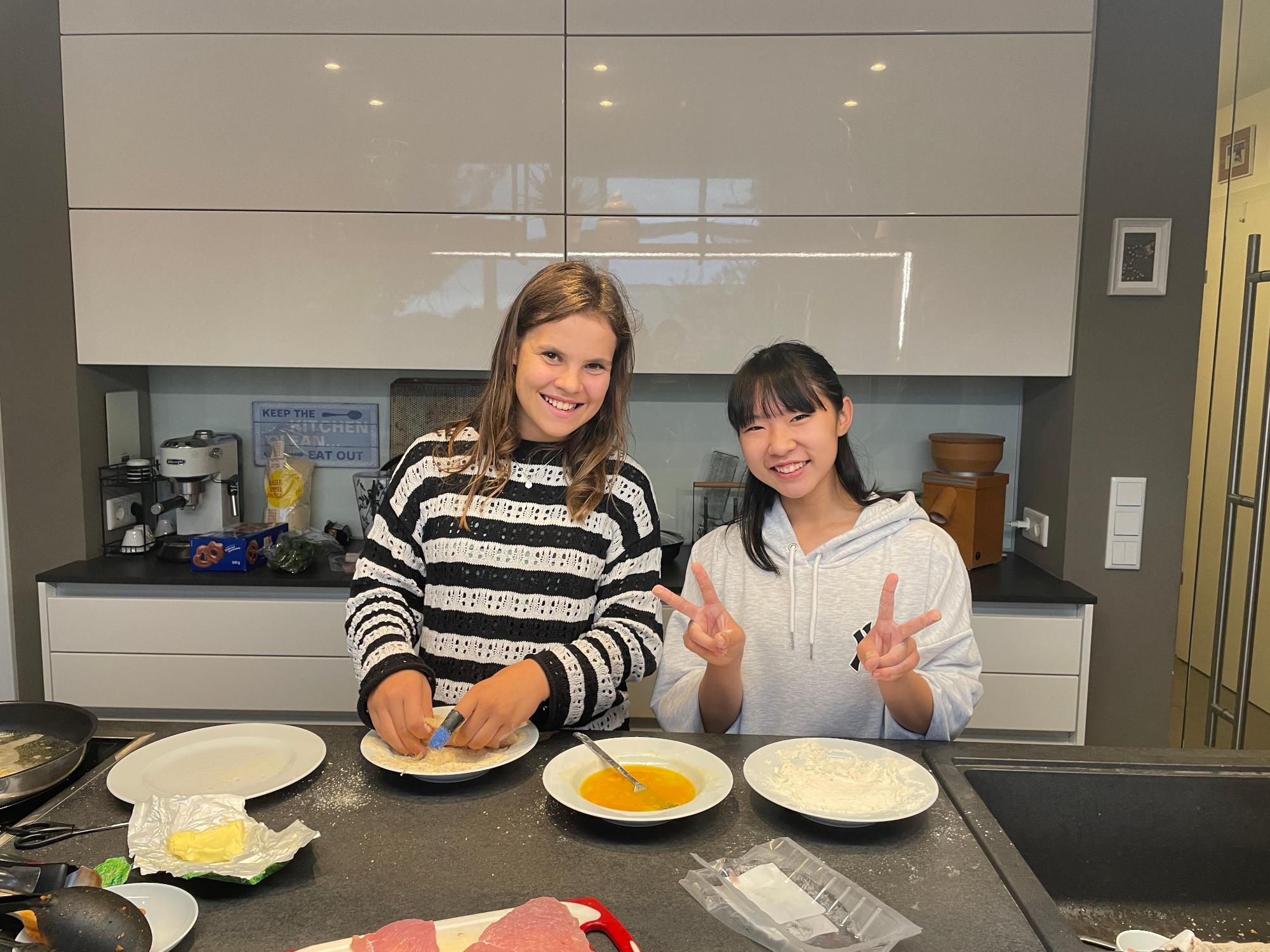 日本人生徒とホストパートナが一緒に料理をしている写真。