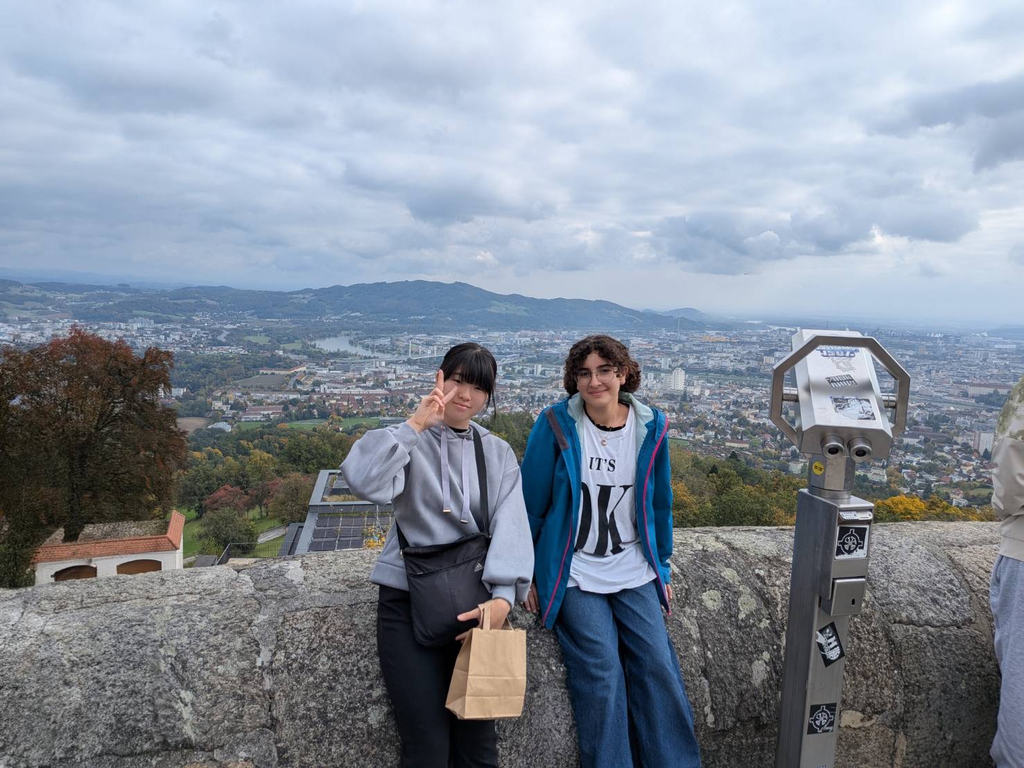 中学生がホストパートナーとポーズしている様子。写真の背景には、オーストリアの町並みが写っている。