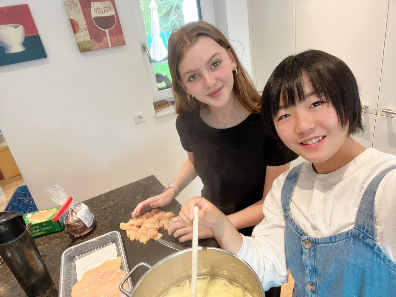 日本人生徒とホストパートナが一緒に料理をしている写真。