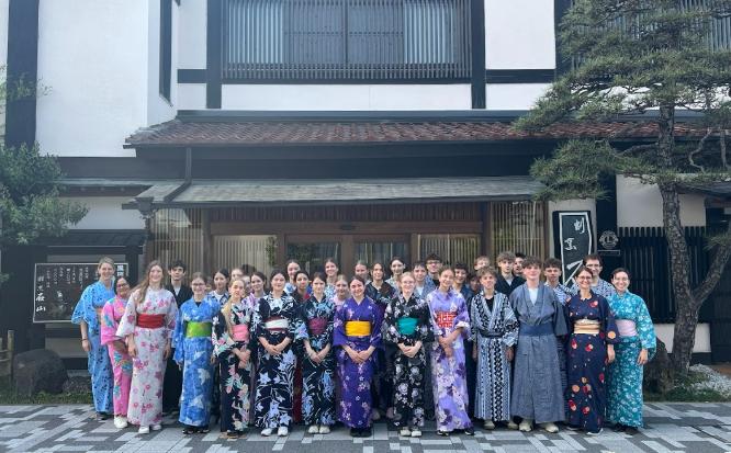 色鮮やかな浴衣を着たアウホフ校の生徒たちが笑顔で並んでいる集合写真。