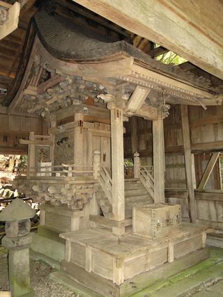 屋内に木造の本殿が建っている写真