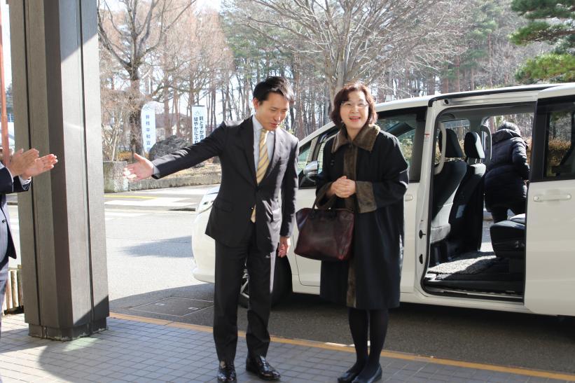 白い車から降りる女性を出迎える市長とのツーショット写真
