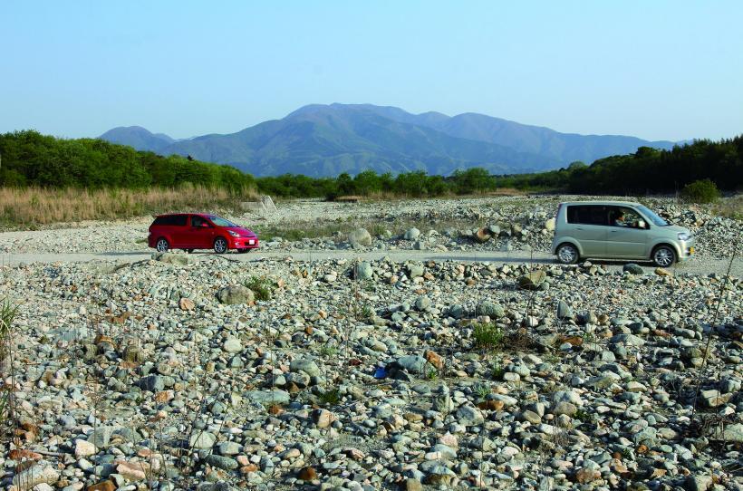 蛇尾川の河原を2台の車が横断する道路の写真