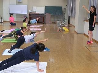 床に敷いたマットの上で子供たちがトレーニングしている写真