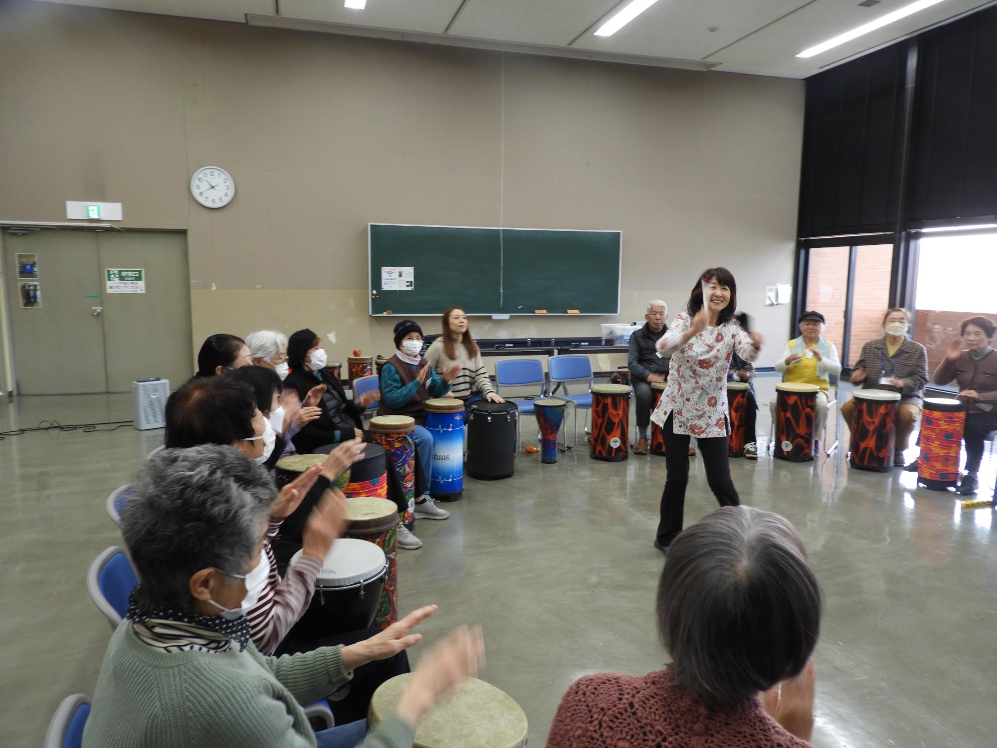 輪になって打楽器を演奏する様子
