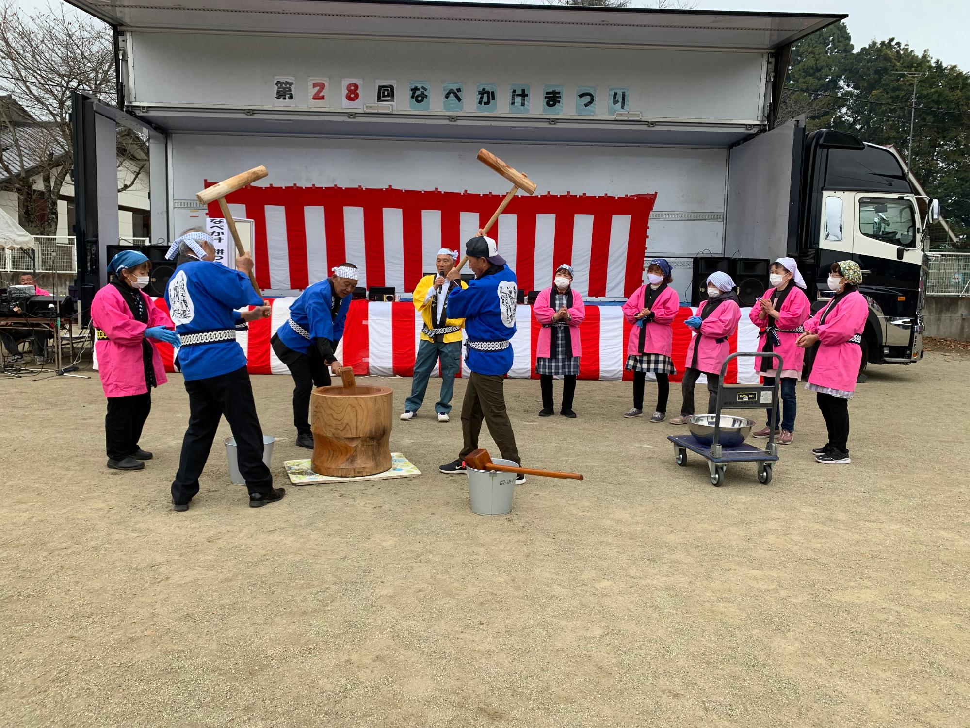 白い屋台の前を多くのなべかけまつり参加者が埋めつくしている写真