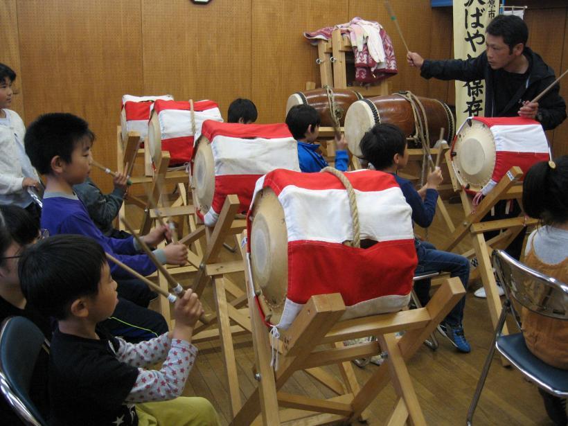 太鼓の練習をしている子ども達と先生の様子の写真