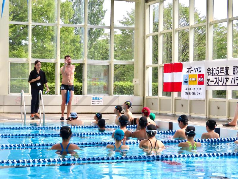 生徒に水泳の指導するオネア選手の通訳をする国際交流員