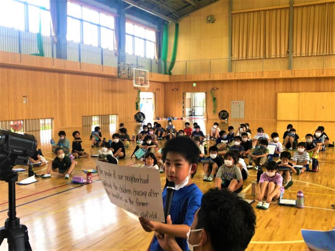 選手に一生懸命英語で説明する児童
