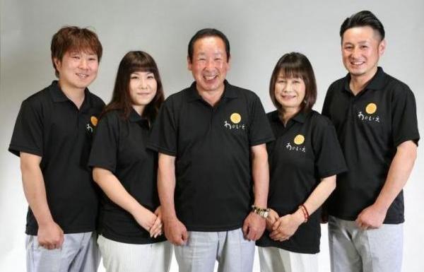 黒いシャツを着た3名の男性と2名の女性が並んで笑顔で写真に映る様子の株式会社ムロイハウジングの写真