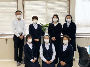 職場で2列に並んだユニフォーム姿の職員たちの写真