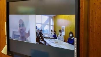 市立厚崎中学校の特別教室でおこなわれたオンライン交流会において、フリューヴィルト選手と生徒たちの画面が横に並んで分割表示されている電子黒板の写真