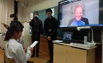 市立埼玉小学校の教室でおこなわれたオンライン交流会において、児童の発表を笑顔で聞くシャッタウアー選手を映し出した電子黒板の写真