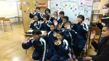 市立東那須野中学校の教室でおこなわれたオンライン交流会において、手を振りながらオネア選手と会話する生徒たちの写真