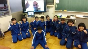 市立厚崎中学校の教室でおこなわれたオンライン交流会において、電子黒板に映し出されたフリューヴィルト選手とともに記念撮影をする生徒たちの写真