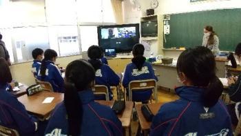 市立厚崎中学校の教室でおこなわれたオンライン交流会において、フリューヴィルト選手と会話をする生徒たちを後ろから撮影した写真