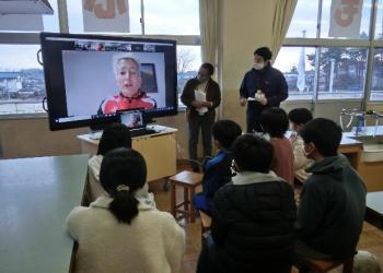 市立東原小学校の特別教室でおこなわれたオンライン交流会において、電子黒板に映し出されたマルツィンケ選手の話を聞く児童たちを後ろから撮影した写真