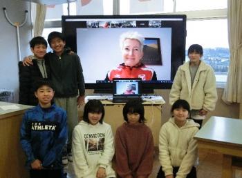 市立東原小学校の特別教室でおこなわれたオンライン交流会において、電子黒板に映し出されたマルツィンケ選手とともに記念撮影をする児童たちの写真