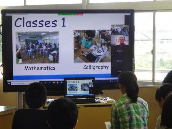 市立東原小学校の特別教室でおこなわれたオンライン交流会において、マルツィンケ選手に自分たちの学校を紹介する児童たちの写真。電子黒板には数学と書道の授業の写真が映し出されている。