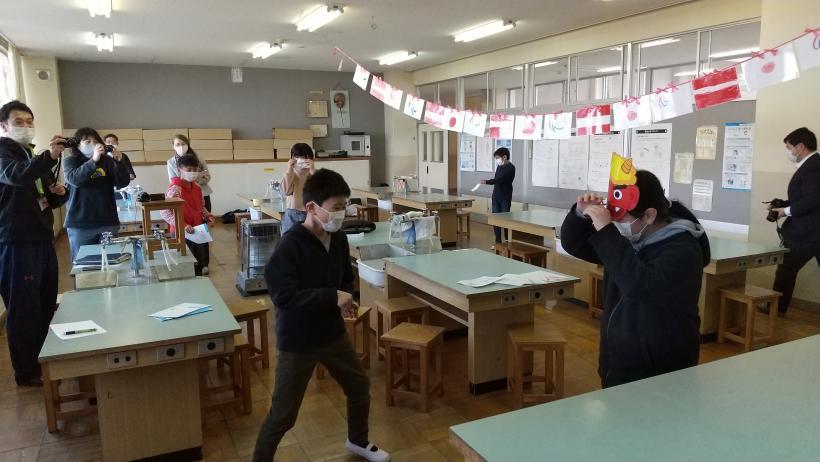 市立東原小学校の教室でおこなわれたオンライン交流会にて、マルツィンケ選手に豆まきの実演を披露する2人の児童たちの写真