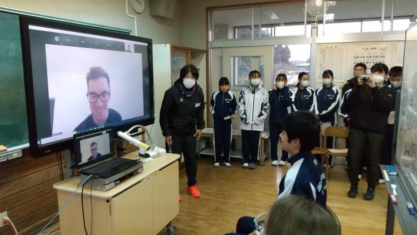 市立東那須野中学校でのオンライン交流会にて、教室に置かれた電子黒板を介してオネア選手に質問をする1年生代表の写真