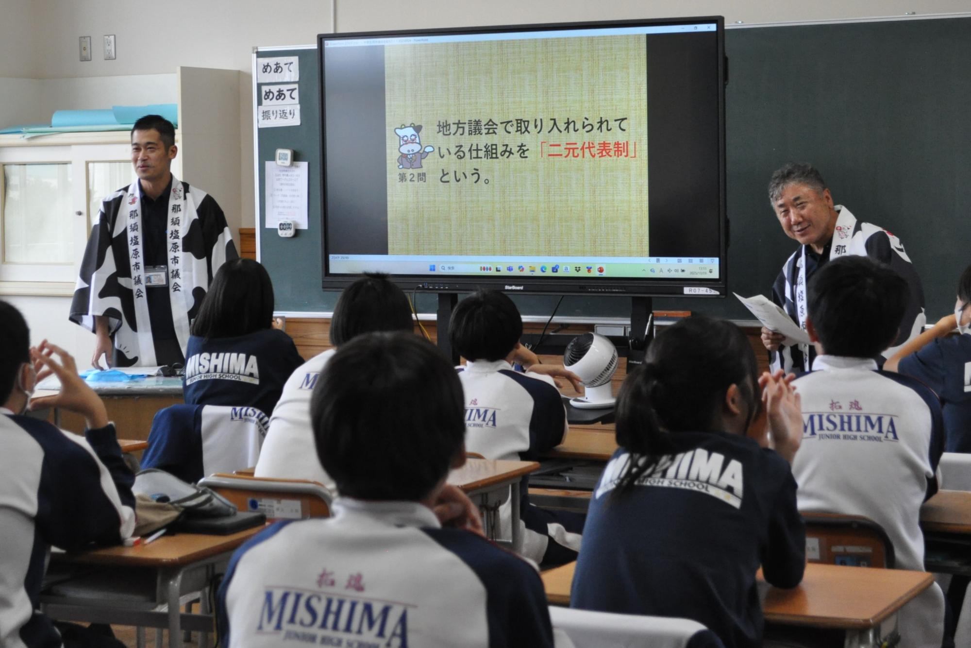 スーツの上にはっぴを着た2人の男性が話をしている写真