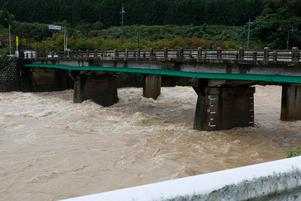 堰場橋の真下を雨水が濁流となって流れている様子の写真